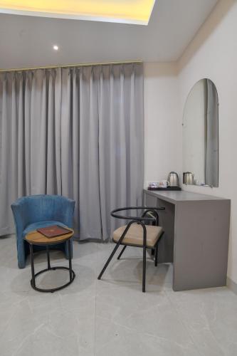 a room with a table and two chairs and a mirror at Aceotel Select Virat, Vijay Nagar in Indore