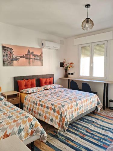 a bedroom with two beds and a desk at Ca Giulia in Chioggia