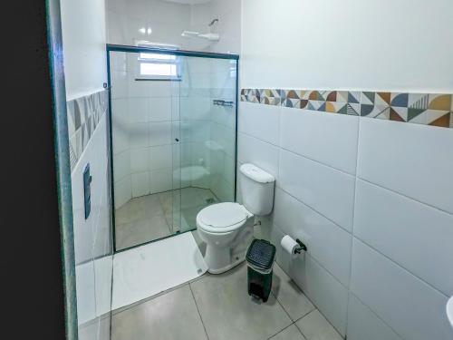 a bathroom with a toilet and a glass shower at Hotel Pousadas Club Smart in Sorocaba