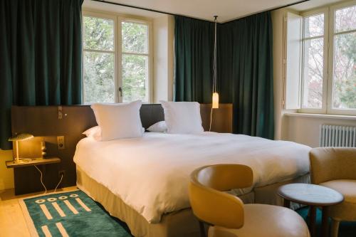 a hotel room with a large bed and windows at Villa Tri Men in Combrit