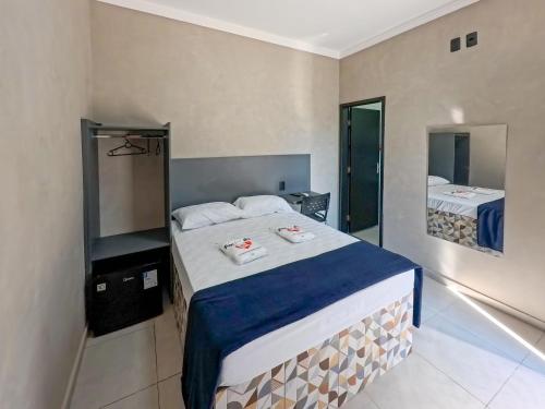 a bedroom with a large bed and a mirror at Hotel Pousadas Club Smart in Sorocaba