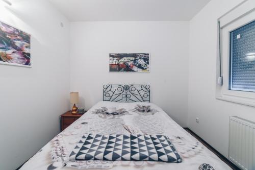 a bedroom with a bed with a black and white bedspread at Sreckovic Apartmani 2 in Kragujevac