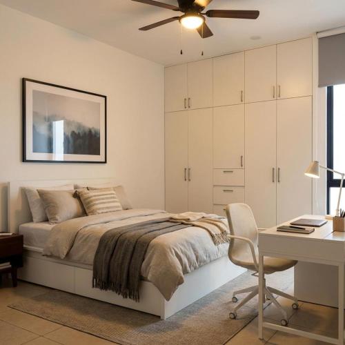 a bedroom with a bed with a desk and a ceiling fan at Departamentos Nütuuk in Mérida