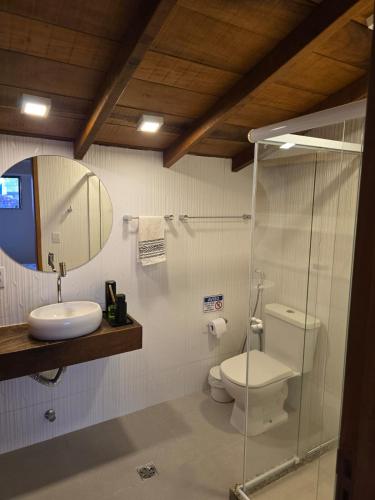 a bathroom with a toilet and a sink and a mirror at Cabana da Cris in Anchieta