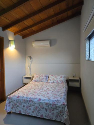 a bedroom with a bed and two night stands at Cabana da Cris in Anchieta