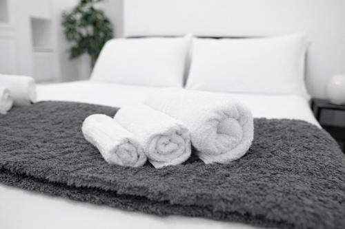 a pile of towels sitting on top of a bed at Le Erbe Apartment tra Locali e vita Universitaria in Genoa