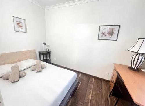 a white bedroom with a bed and a desk at Maison cozy 2p- Jardin - Paris à 5 min - Métro in Maisons-Alfort