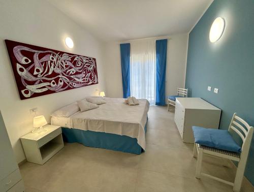 a bedroom with a bed and a painting on the wall at Fortezza Apartments in Le Castella