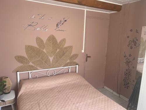 a bedroom with a bed with a large flower on the wall at Le petit coin du pêcheur in Brouchaud