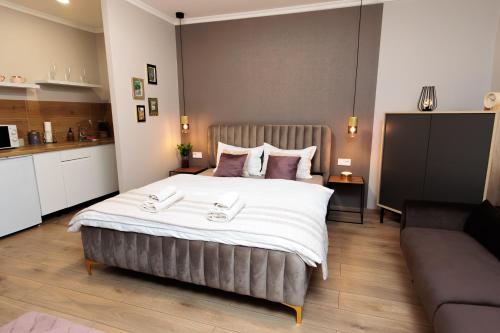 a bedroom with a large bed and a couch at KB House apartman in Malý Horeš