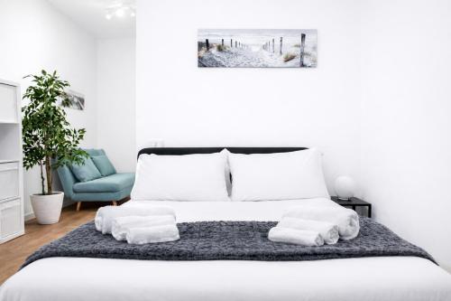 a white bedroom with a bed with towels on it at Le Erbe Apartment tra Locali e vita Universitaria in Genoa