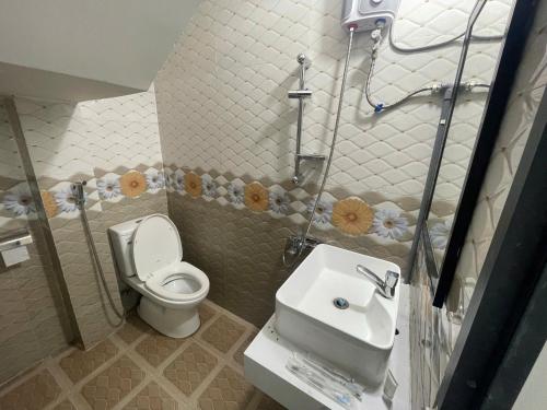 a small bathroom with a toilet and a sink at Lami House in Danang