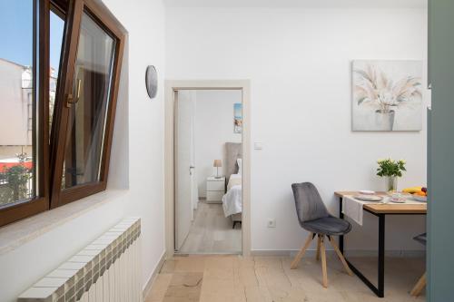 a room with a desk and a chair and a mirror at Apartments Dadic with parking & playground in Medulin