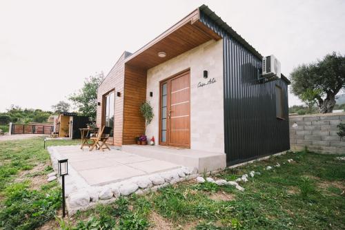 a small house with a wooden door and a patio at Casa Arte in Ulcinj