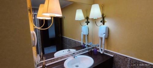 a bathroom with a sink and a mirror and lights at Hotel Barceló Royal Beach in Sunny Beach