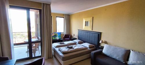 a bedroom with a bed and a couch and a window at Hotel Barceló Royal Beach in Sunny Beach