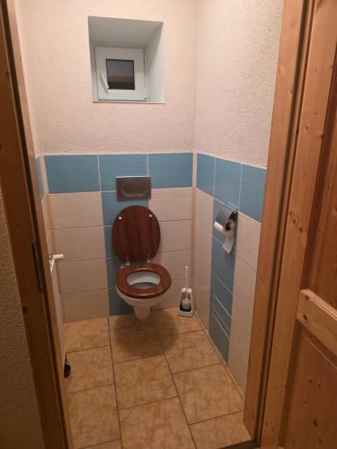 a bathroom with a toilet with a brown seat at Apartmán na statku NH Stables in Nýřany