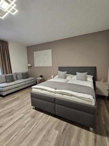 a bedroom with a large bed and a couch at Stadtoase Wels III in Wels