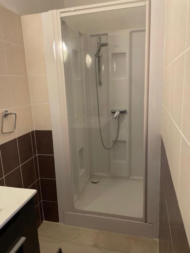 a bathroom with a shower with a glass door at La Canopée in La Gouesnière