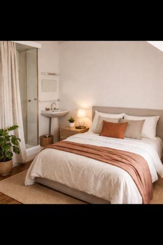 a bedroom with a large bed and a sink at La Canopée in La Gouesnière