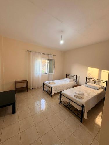 a room with two beds and a window at Dimitris House in Pllakë