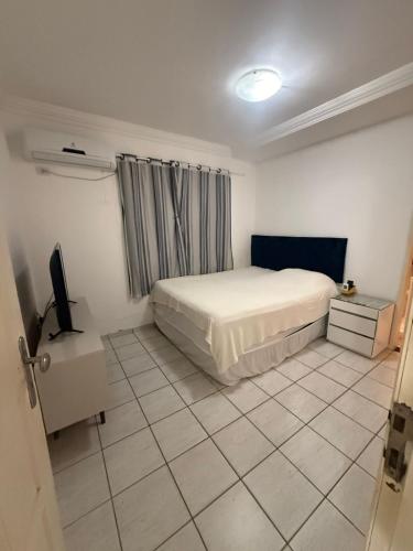 a bedroom with a bed and a tv in it at Natal Exclusive Pool Villa Private Community in Natal