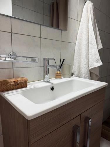 a bathroom with a white sink and a towel at Emari Apartments in Heraklio
