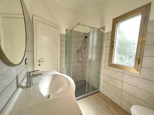 a white bathroom with a sink and a shower at Bed & Breakfast Alex in Capoliveri