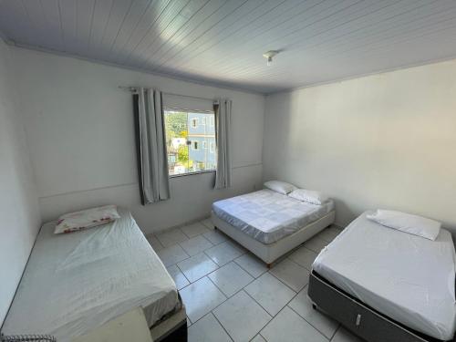 a room with two beds and a window at Suites da Bela 05 Caparaó in Caparaó Velho