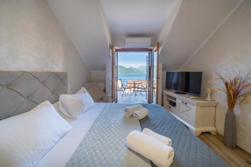 a bedroom with a large bed with a view of the ocean at Apartments Nikčević in Kotor