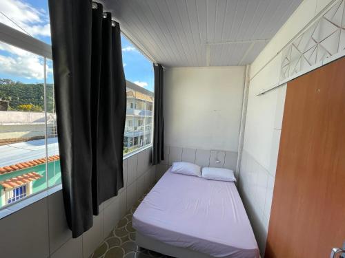 a small bed in a small room with a window at Hospedagem da Bela Quarto 7 Banheiro compartilhado in Caparaó Velho