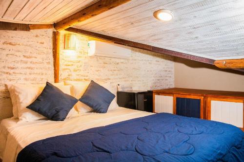 a bedroom with a bed with blue sheets and a wooden ceiling at Coleção Falésias de Pipa- by Arcbio Experience in Pipa