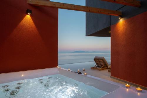 a bath tub with a view of the ocean at River Villas Plomari - Luxury Villas with Direct Pool Access in Plomari