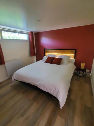 a bedroom with a large white bed with red walls at Appartement - Cestas in Cestas