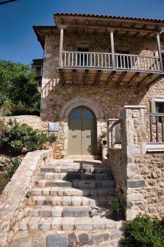 a stone house with a door and stairs leading to it at Miglari in Stemnitsa