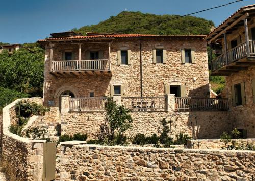 an old stone house with a stone wall at Miglari in Stemnitsa