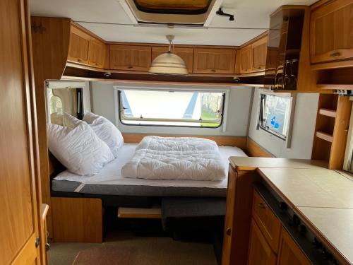 a small bed in the middle of a small room at Campingurlaub Sehlendorf in Blekendorf