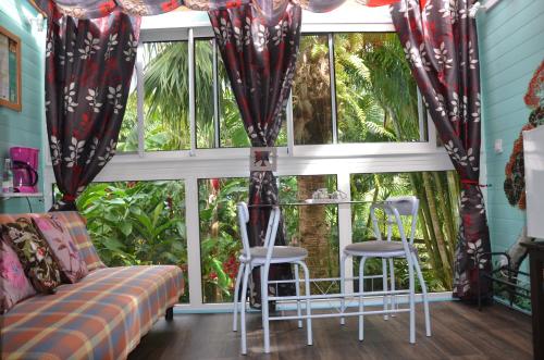 a living room with a couch and chairs in front of a window at Pinpin D'amour in Basse Vallée