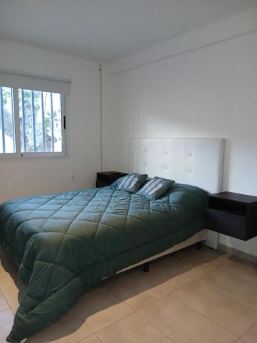 a bedroom with a large green bed and a window at Monoambiente en el centro de Zarate in Zárate