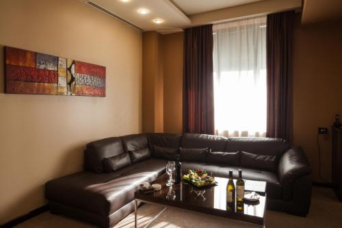 a living room with a leather couch and a table at Avangard Hotel in Yerevan
