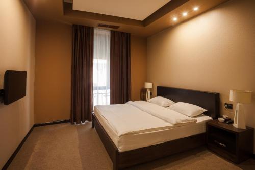 a bedroom with a large bed and a window at Avangard Hotel in Yerevan