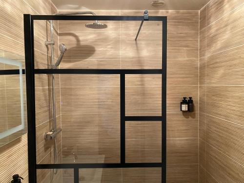 a shower with a glass door in a bathroom at MAISON GERMÈS - CENTRAL & STANDING - Appartements traversants - Lits 180 King Size - Linge de lit et de toilette inclus - Parking privé - Espace Télétravail in Luchon