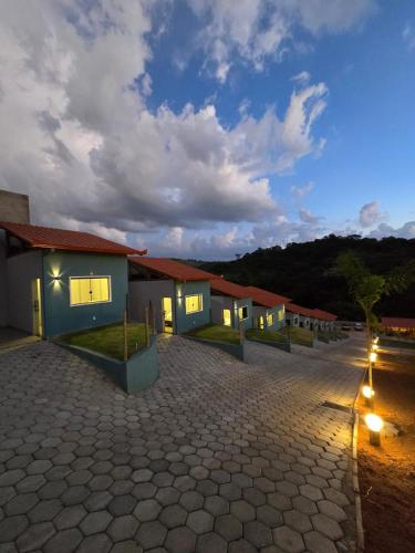 a row of houses with lights in a parking lot at Pousada real chalés in Belo Vale