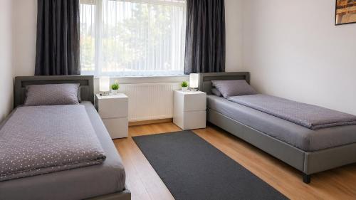a bedroom with two beds and a window at Apollo Home - Im Zentrum der Natur in Wildflecken