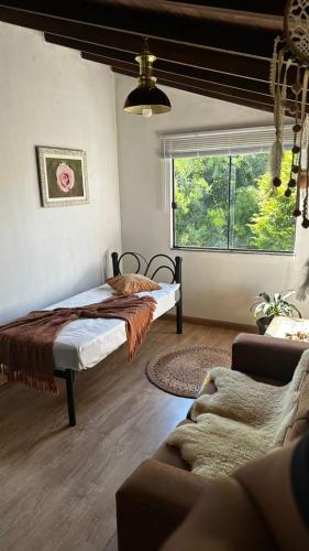 a bedroom with a bed and a window at Refúgio Aroma do Campo in Bagé