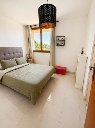 a bedroom with a large bed and a window at Charme provençal près de Nice in Blausasc
