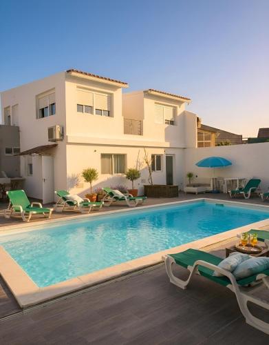 a swimming pool in front of a house at Seixal Bay Village - Estúdio Vista Piscina in Seixal