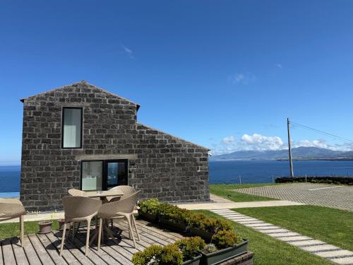 a stone house with a table and chairs at João de Oliveira casas de campo in Santo António