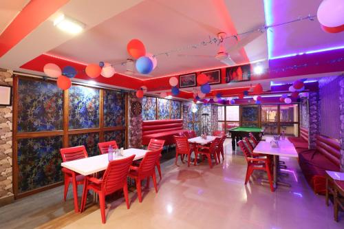 a restaurant with tables and chairs and purple lighting at Hotel O Sher E Bengal in Durgāpur