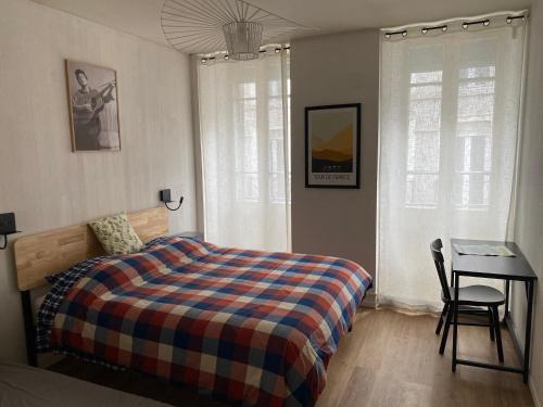 a bedroom with a bed and a table and a desk at MAISON GERMÈS - CENTRAL & STANDING - Appartements traversants - Lits 180 King Size - Linge de lit et de toilette inclus - Parking privé - Espace Télétravail in Luchon